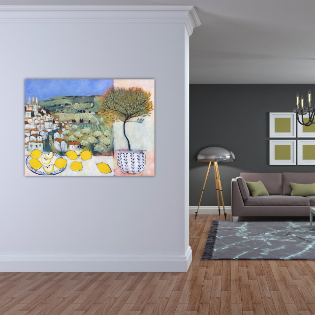 A colorful painting on a white wall depicts a landscape with a village, trees, and a striped potted plant with a large greenish-black leafy branch. The room features a living area with a gray wall, framed artwork, a modern floor lamp, a gray sofa with green pillows, a chandelier, and a patterned area rug.