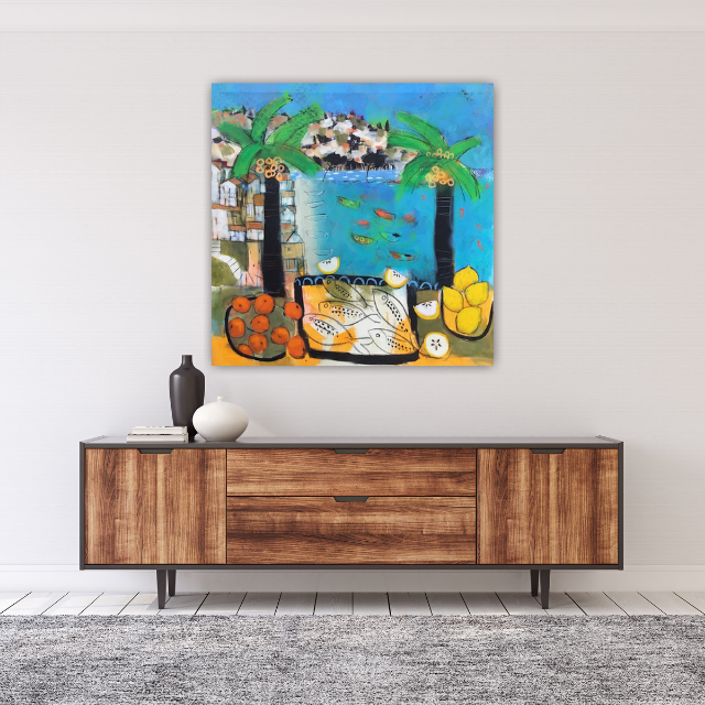 Colorful painting of a tropical scene with water, fish, palm trees, and fruit hanging near the shore, mounted above a wooden sideboard with vases and books on it.