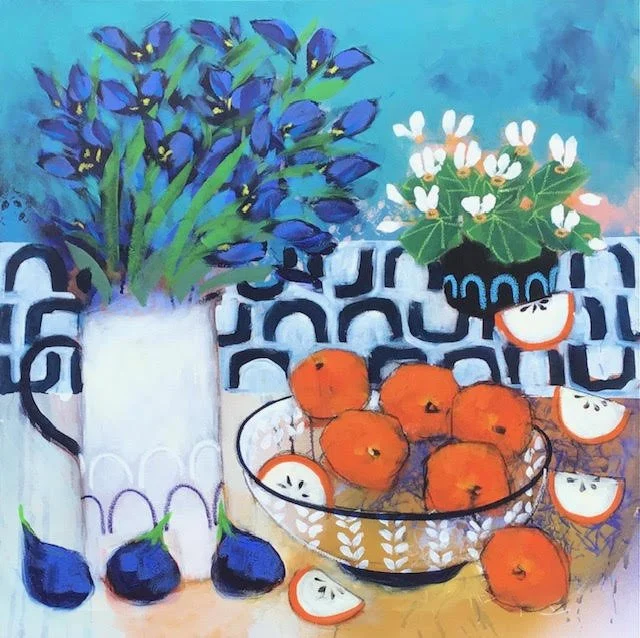 A still life painting featuring a bouquet of blue irises in a white vase, a smaller potted plant with white flowers and green leaves, and a glass bowl filled with oranges and sliced oranges on a table with a patterned blue and white cloth background.