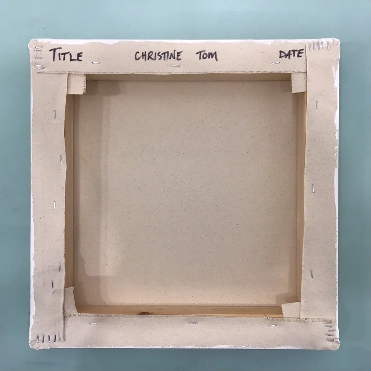 Empty canvas with handwritten labels at the top reading 'Title,' 'Christine,' 'Tom,' and 'Date,' placed on a blue-green surface.