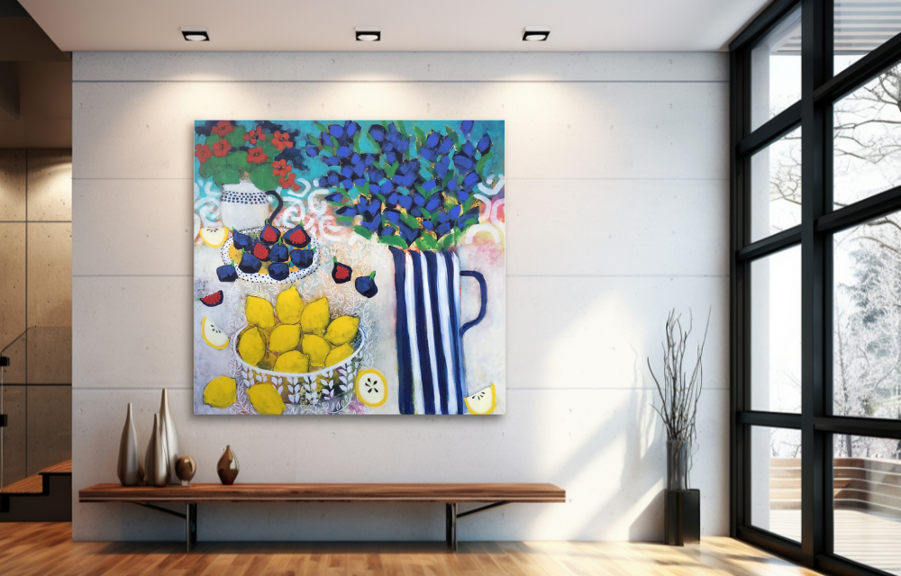 Colorful still life painting of a teapot, berries, lemons, and a bouquet of blue and green leaves in a striped blue and white vase hanging on a white wall in a modern, well-lit room.