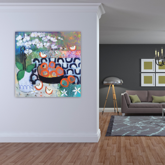 Colorful abstract painting of a bowl with oranges, leaves, and flowers hanging on a white wall in a modern living room.