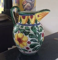 Decorative ceramic pitcher with colorful floral and fruit patterns