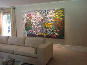 Large floral painting with various colorful flowers on a wall in a living room.
