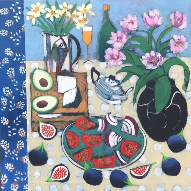 Colorful still life painting of flowers, fruits, and kitchenware on a table, featuring a black vase with pink flowers, a blue ceramic teapot, sliced figs, avocado halves, a bottle, glass, and a halved pomegranate, with a patterned blue cloth on the left.