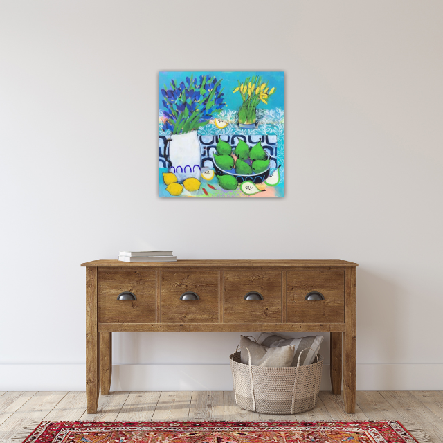 Colorful still life painting of flowers and vases hung above a wooden console table in a minimalist room.