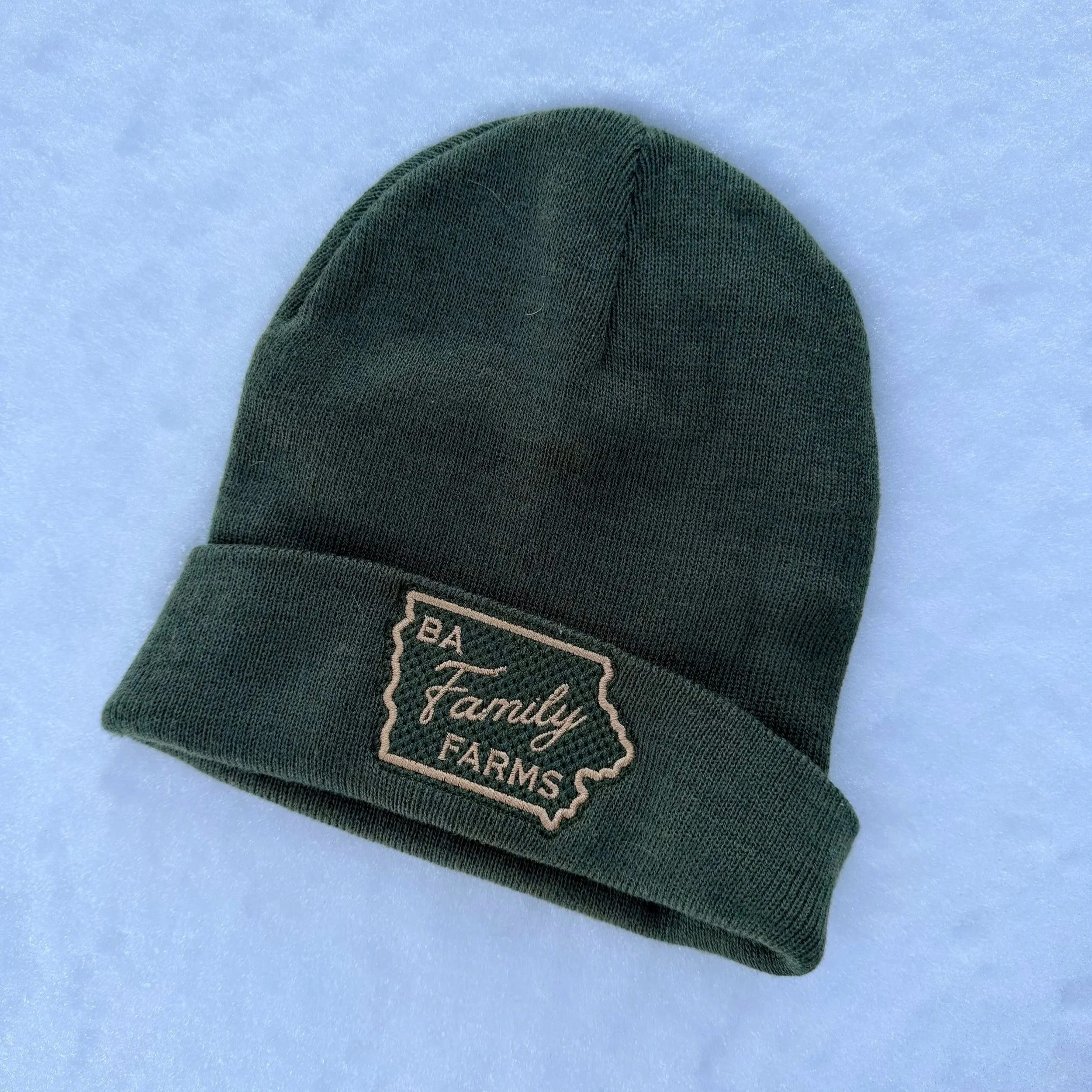 Green knit beanie hat with a patch that reads 'BA Family Farms' and an outline of the state of Iowa