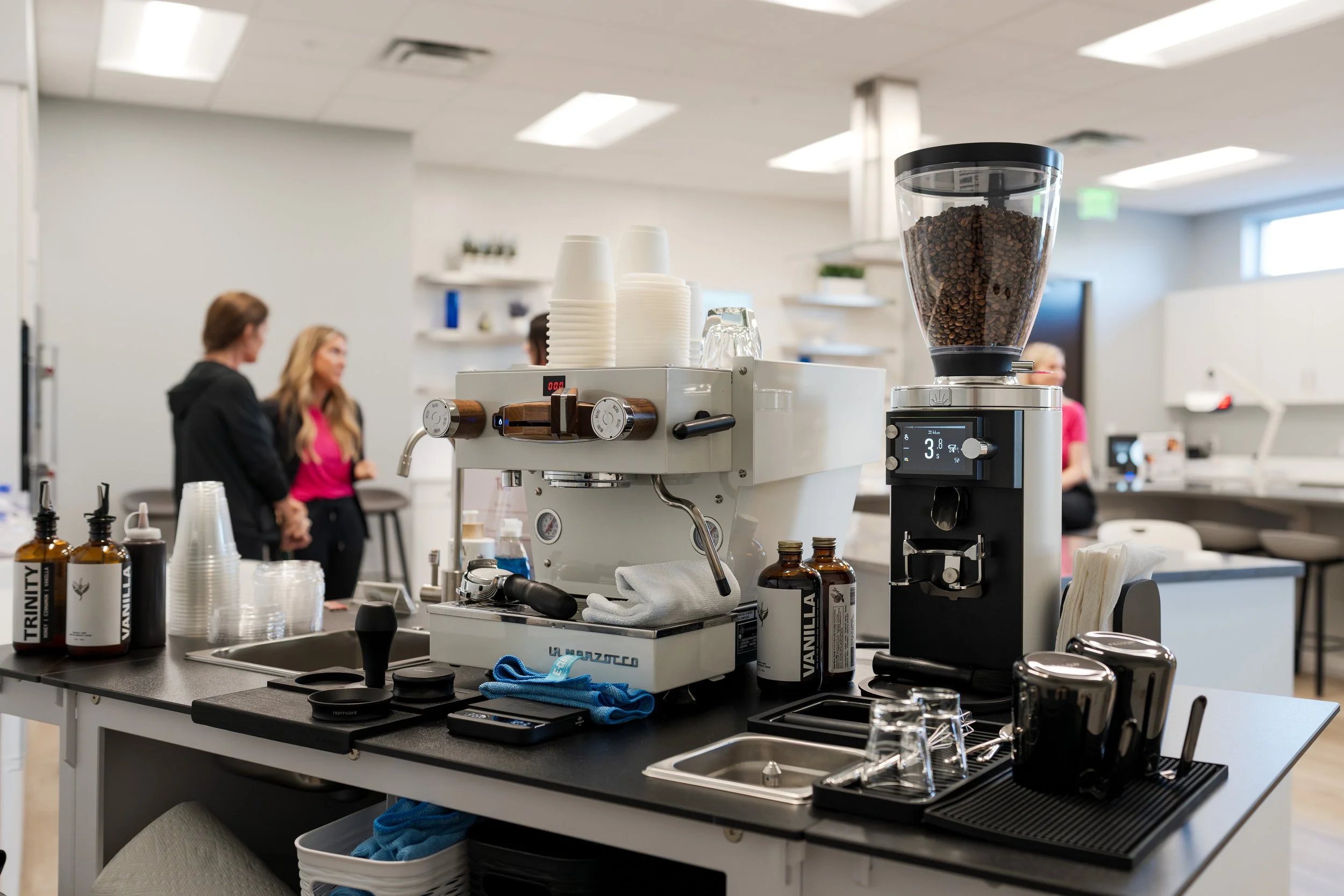 Preamble Coffee Cart's mobile espresso bar fully set up and ready to serve customers premium espresso drinks at a sponsored event for a family medical practice in Carmel, Indiana with cups, coffee beans, grinder, scale, and coffee tools.