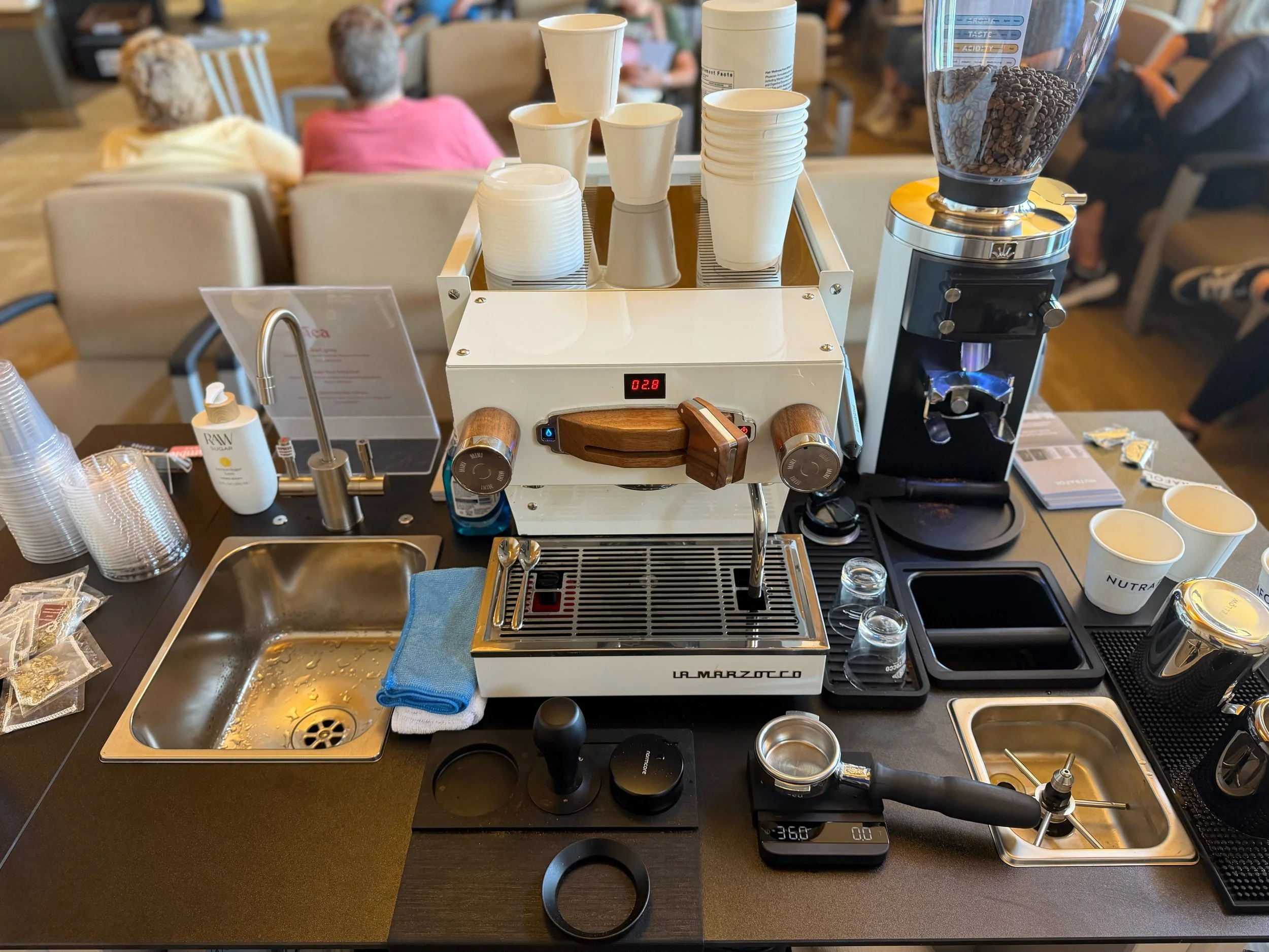 Preamble Coffee Cart's mobile espresso bar fully set up and ready for customers at a sponsored event at a dermatology office with cups, coffee beans, grinder, scale, and tools in Fort Wayne, Indiana.