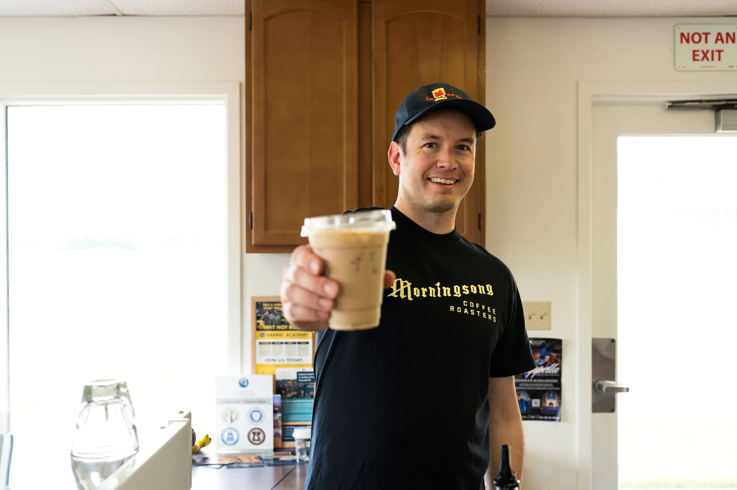 Owner Mark Pape of Preamble Coffee Cart Catering in Fort Wayne, Indiana smiling as he serves an iced latte to a guest at a private event.