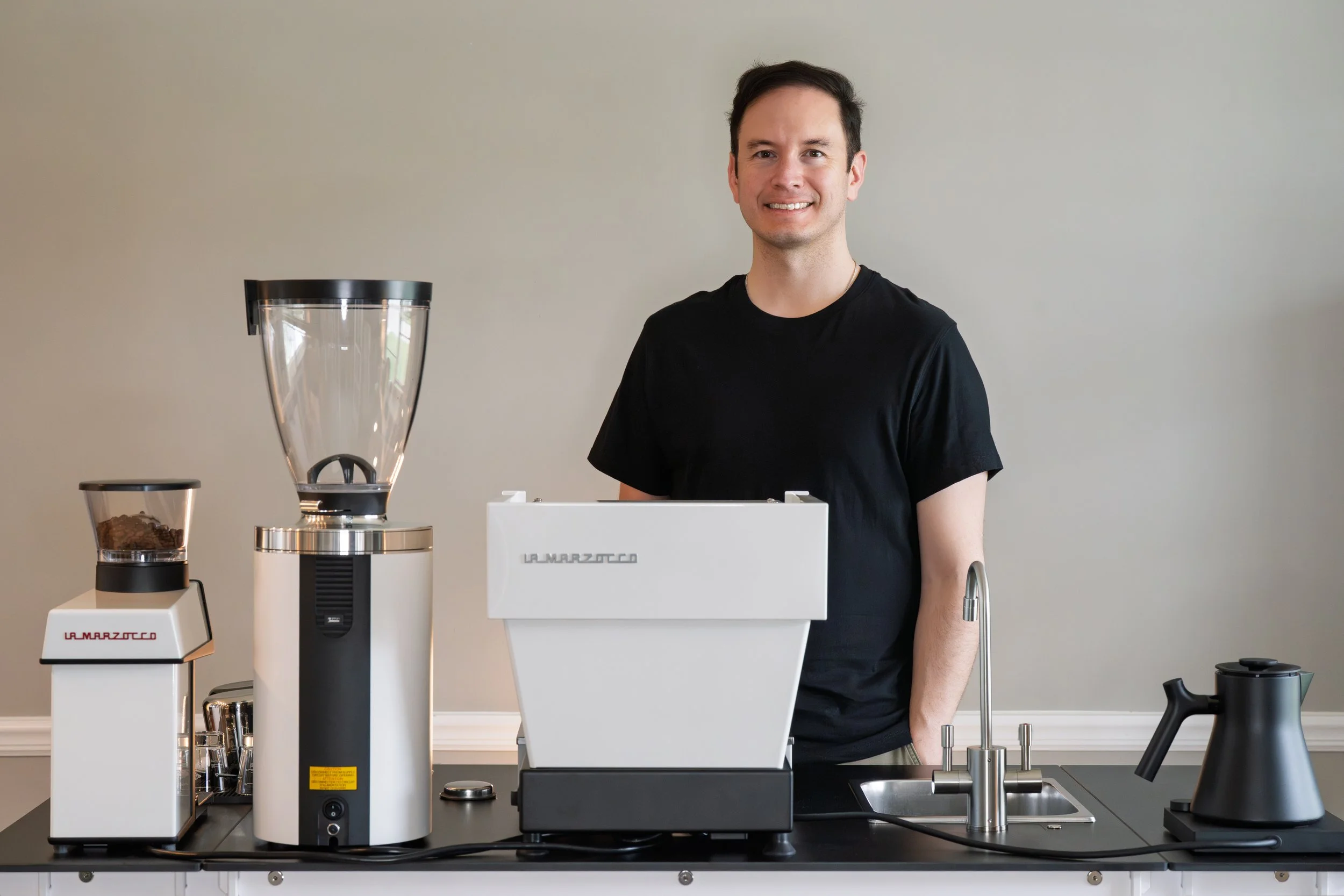 The owner and a barista of Preamble coffee smiling in front of their mobile espresso bar and coffee cart–ready for service.