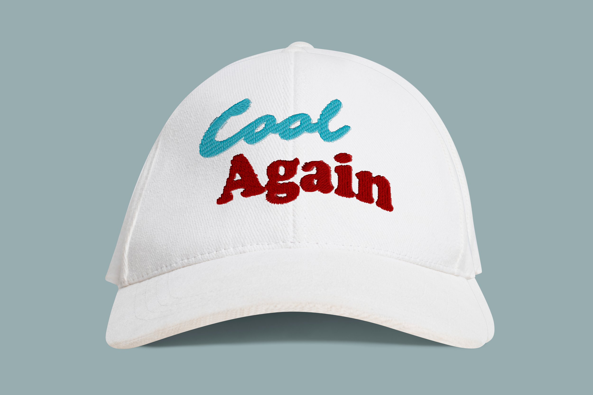 A white baseball cap with blue and red embroidered text that says "Cool Again" on the front, set against a plain gray background.