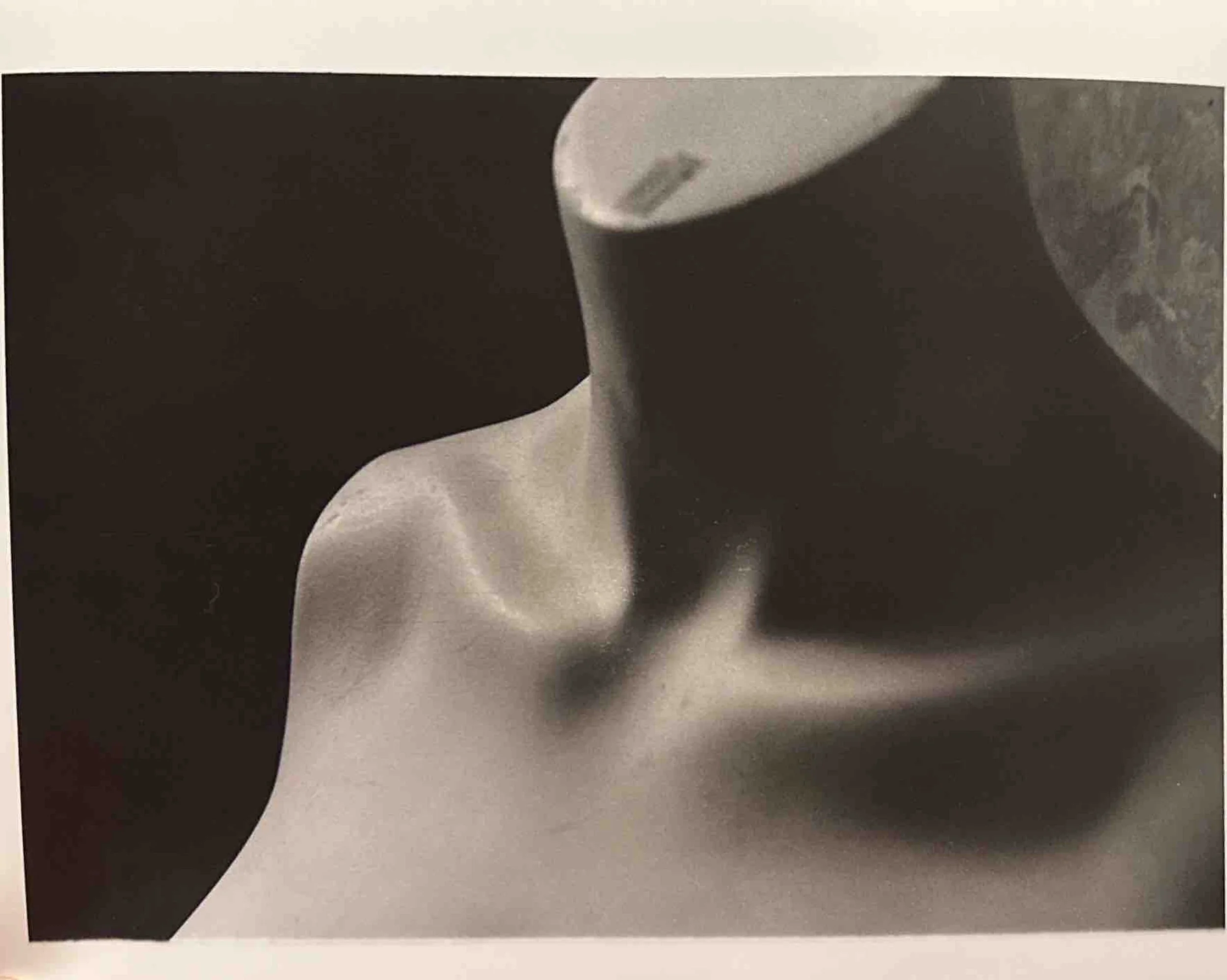 Close-up black-and-white photograph of an abstract sculpture or figure with smooth and flowing shapes.