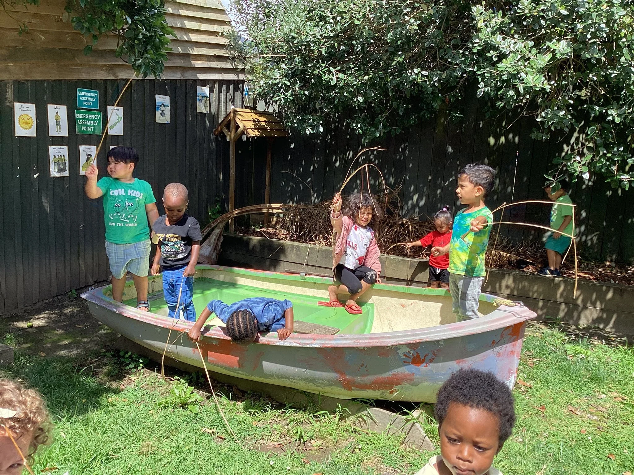 Pukeko Preschool Claudelands Children playing outside near a boat.