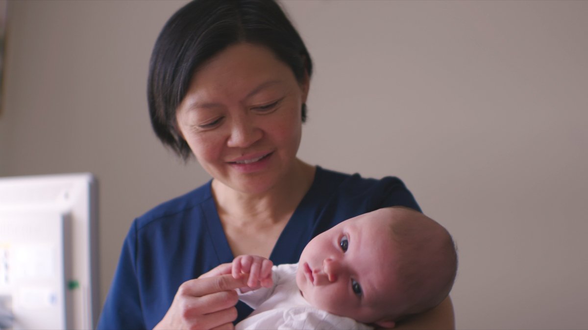female doctor holding baby in arms