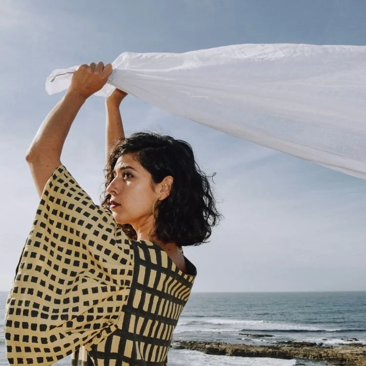 Person holding white cloth blowing in wind