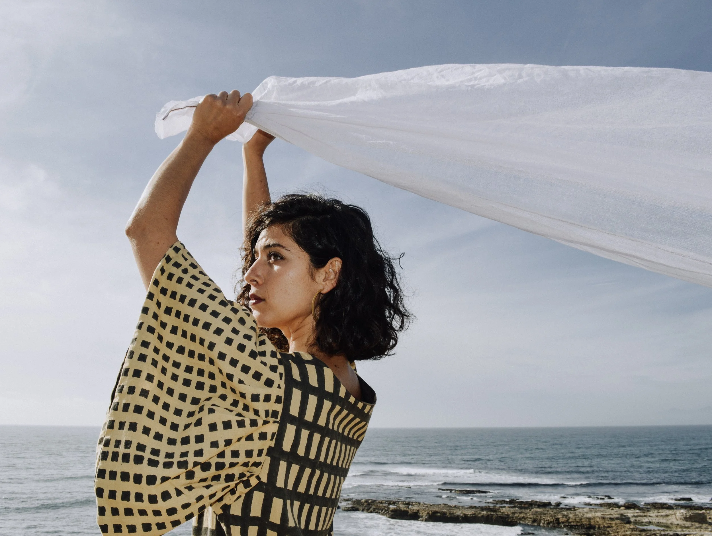 Person holding white cloth blowing in wind
