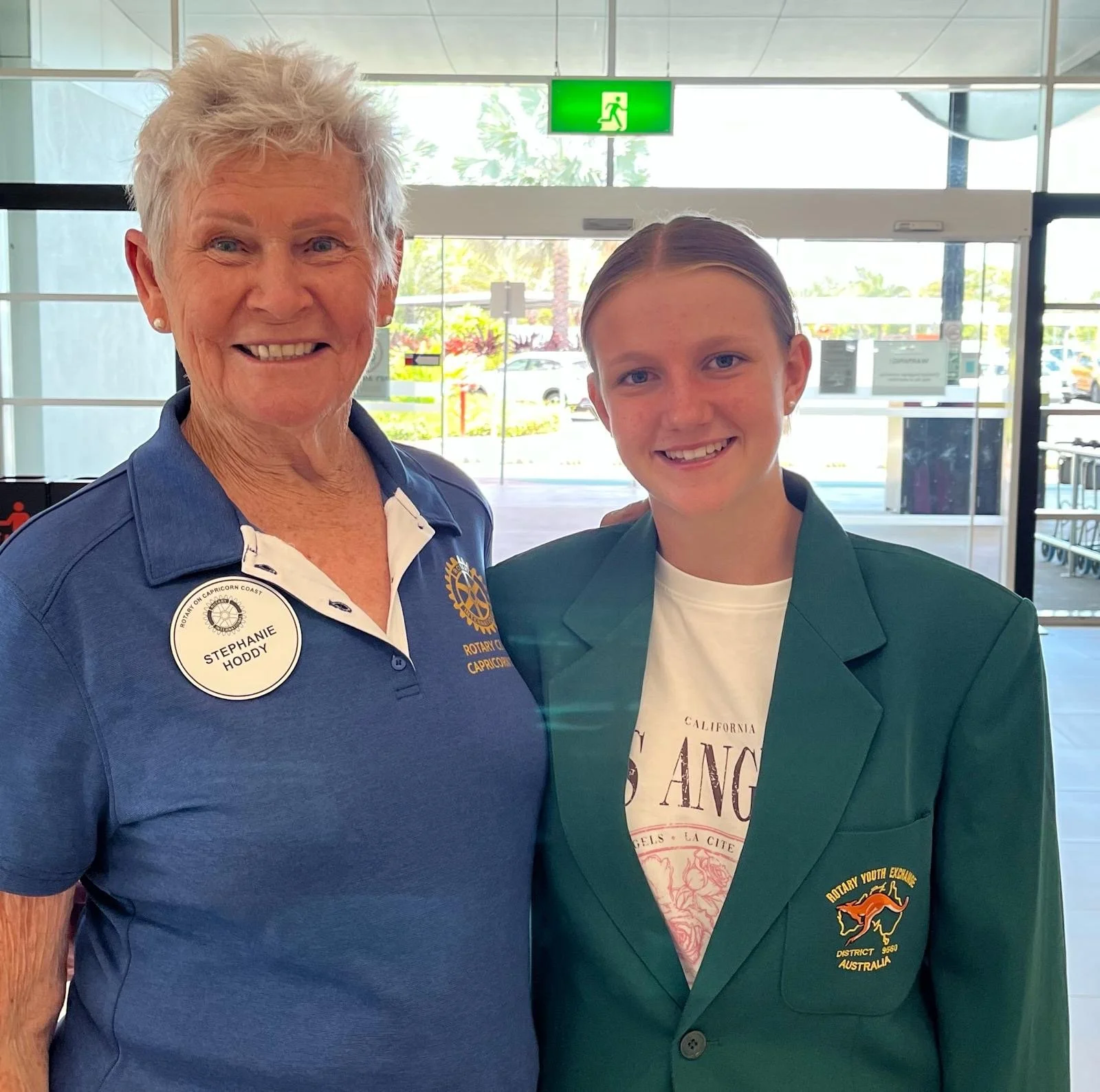 A female Rotary member poses with a young exchange student at airport departues