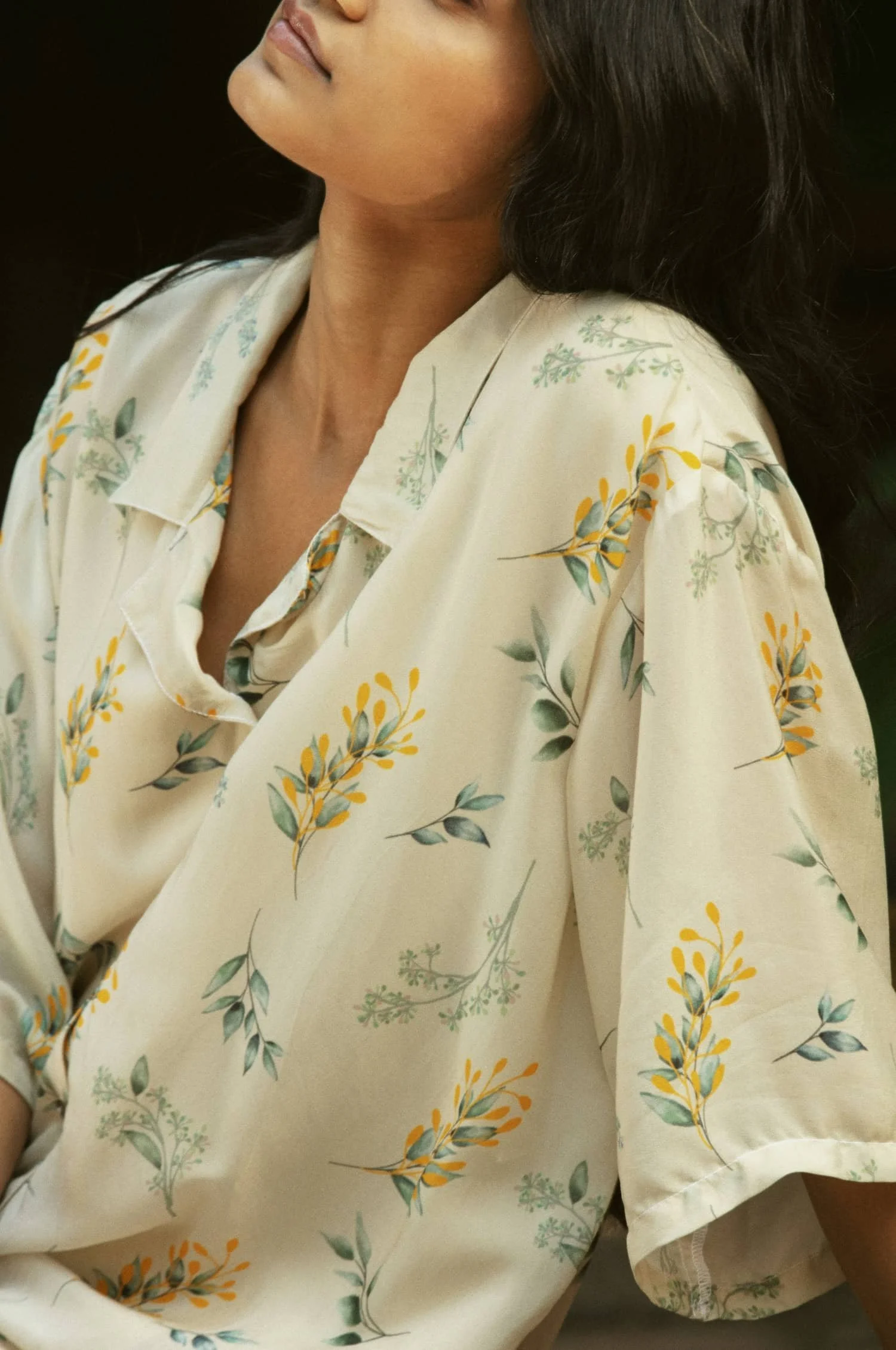 woman in yellow floral shirt leaning back