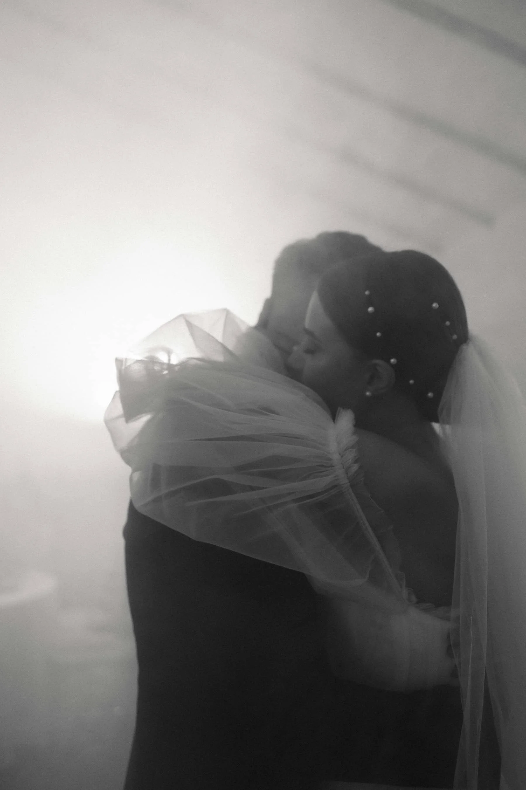 black and white photo of a bride and groom hugging