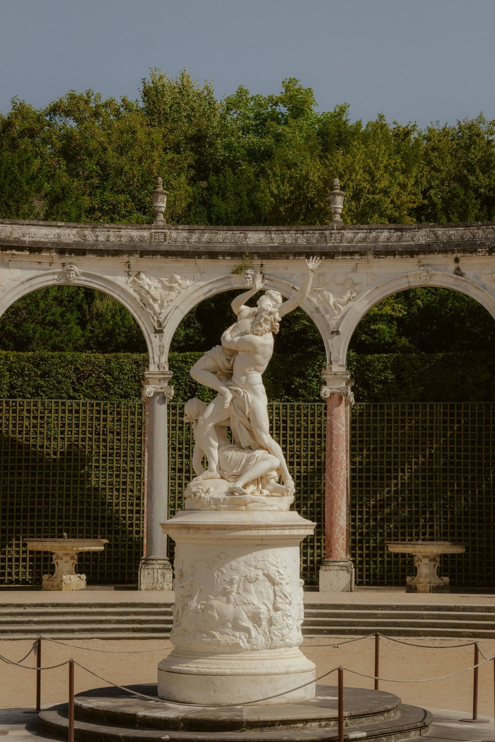 roman statues surrounded by an arched pavilion