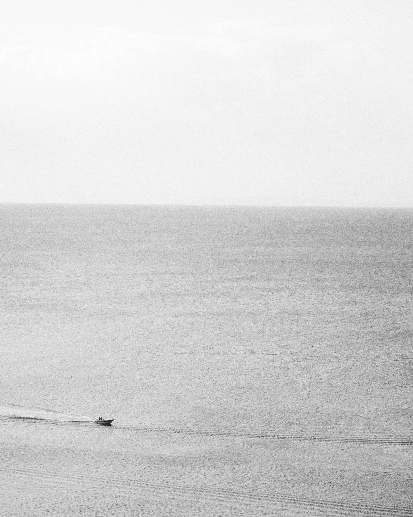 a wide angle view of a speed boat riding across the ocean