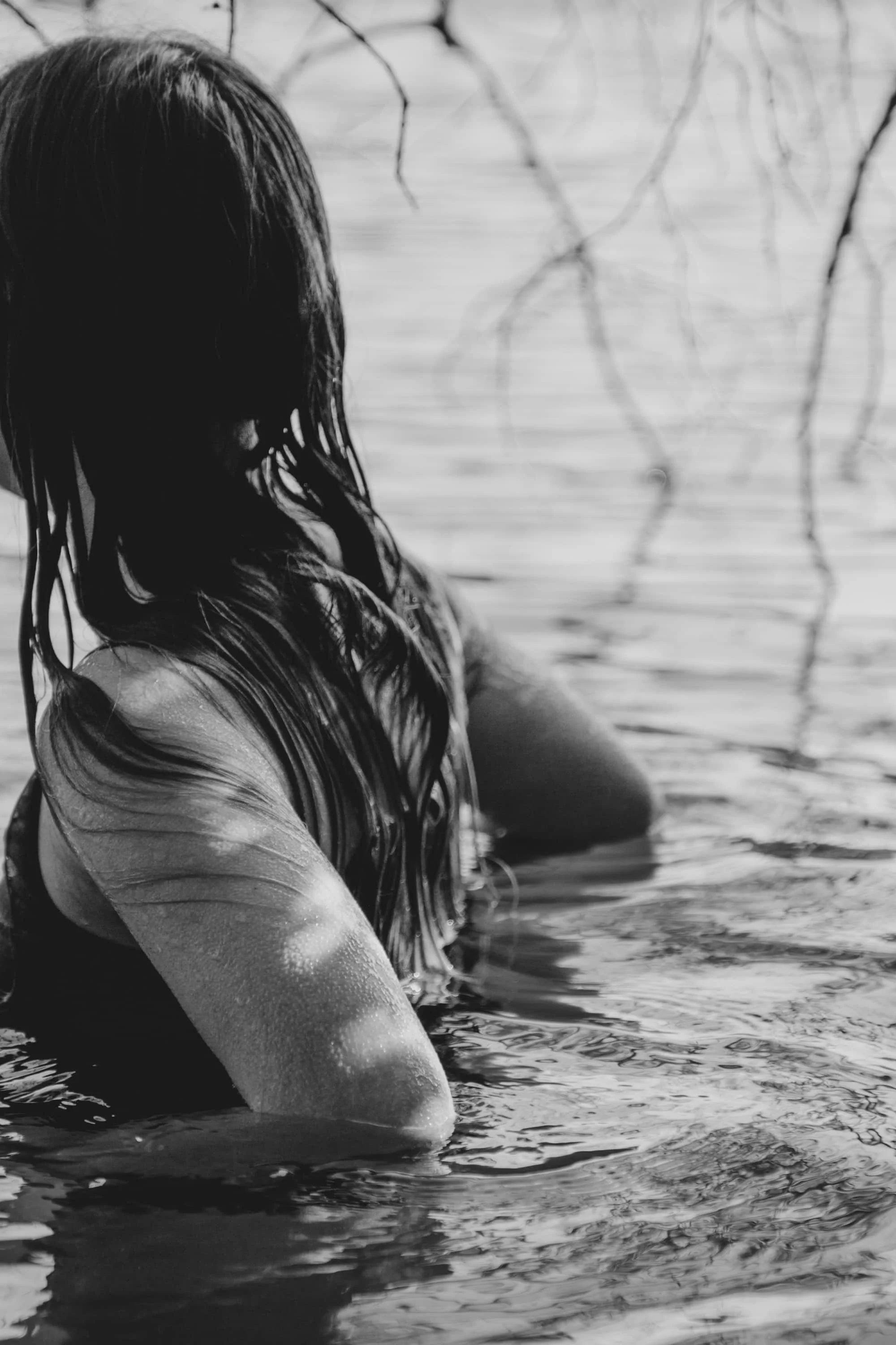 woman swimming in the ocean with her back towards the camera