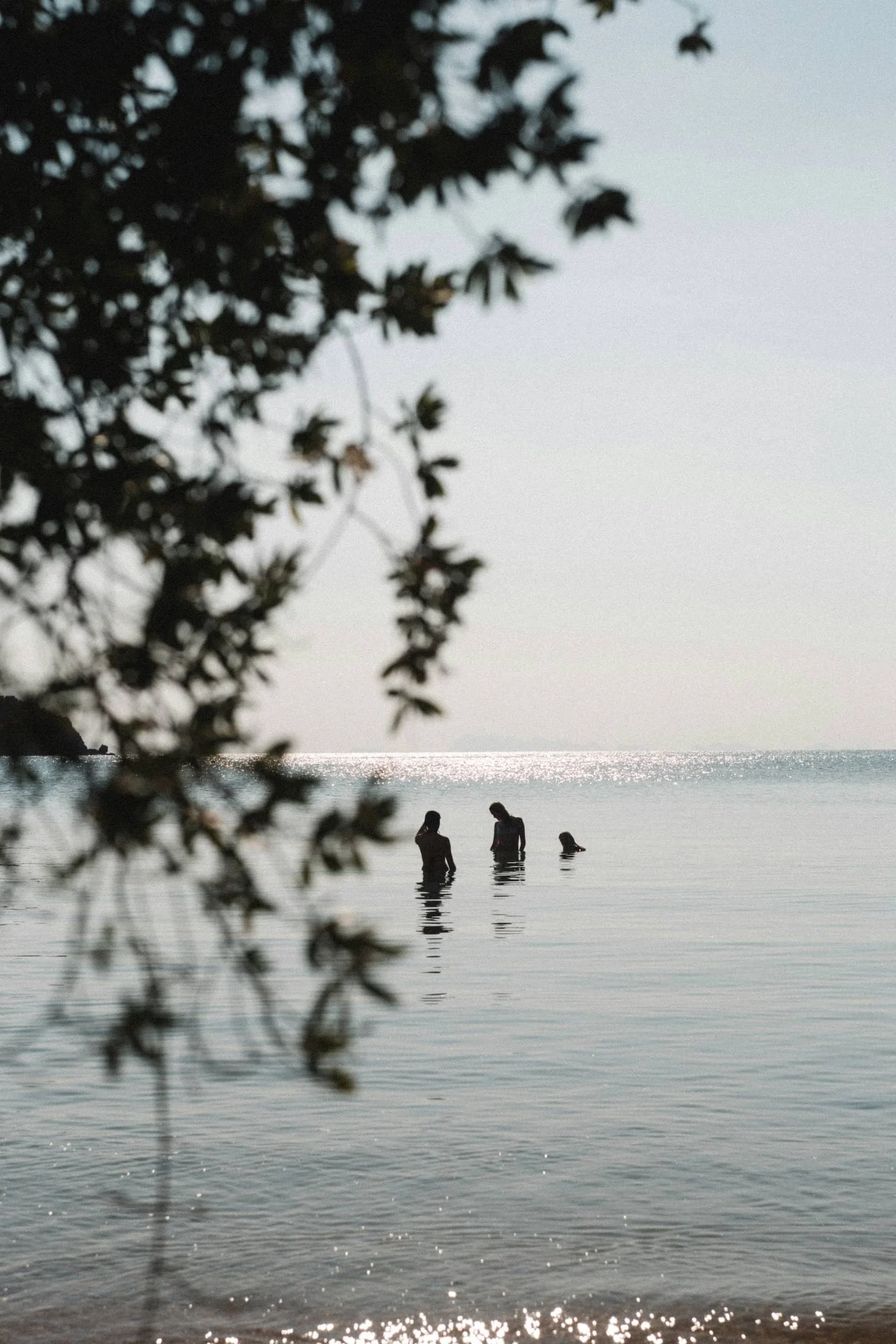 two women standing in the ocean talking to each other
