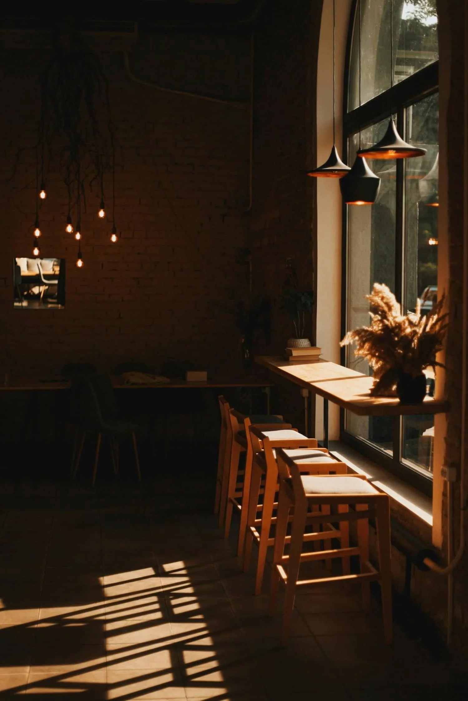 cafe chairs facing a sunny window with dappled light coming through