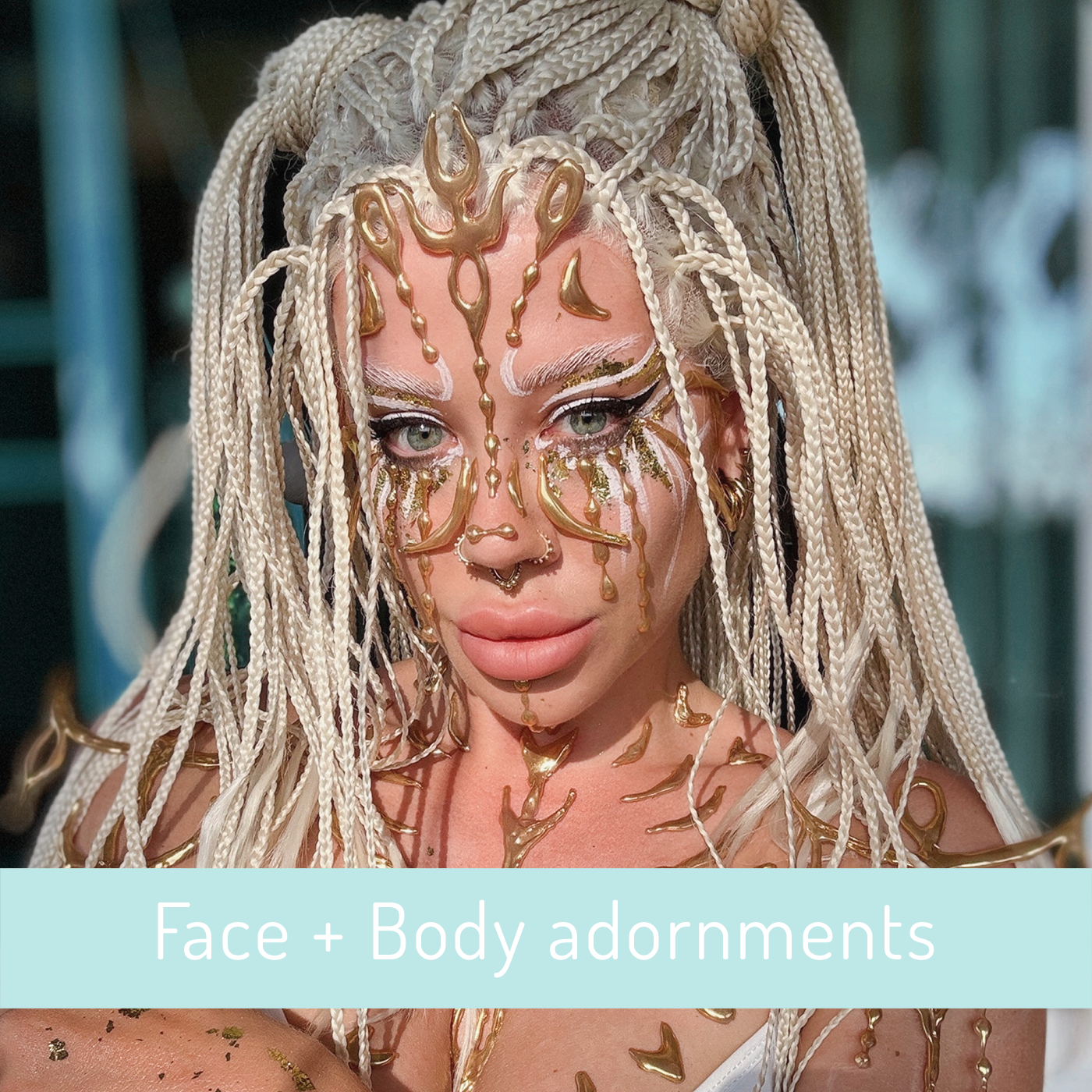A woman with platinum blonde dreadlocks and elaborate gold face and body jewelry, including adornments on her forehead, cheeks, and shoulders.