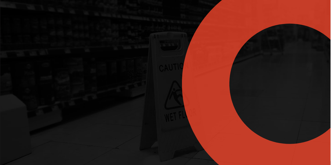A wet floor caution sign in a store aisle with shelves of products, overlaid with a red circle graphic.