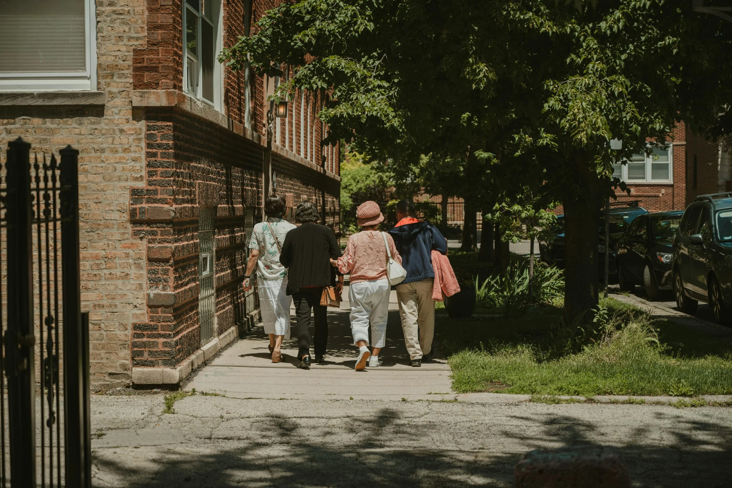 Four elderly women walking together through a residential neighborhood, representing the community and independence protected by Intentional Impact’s guardianship services.
