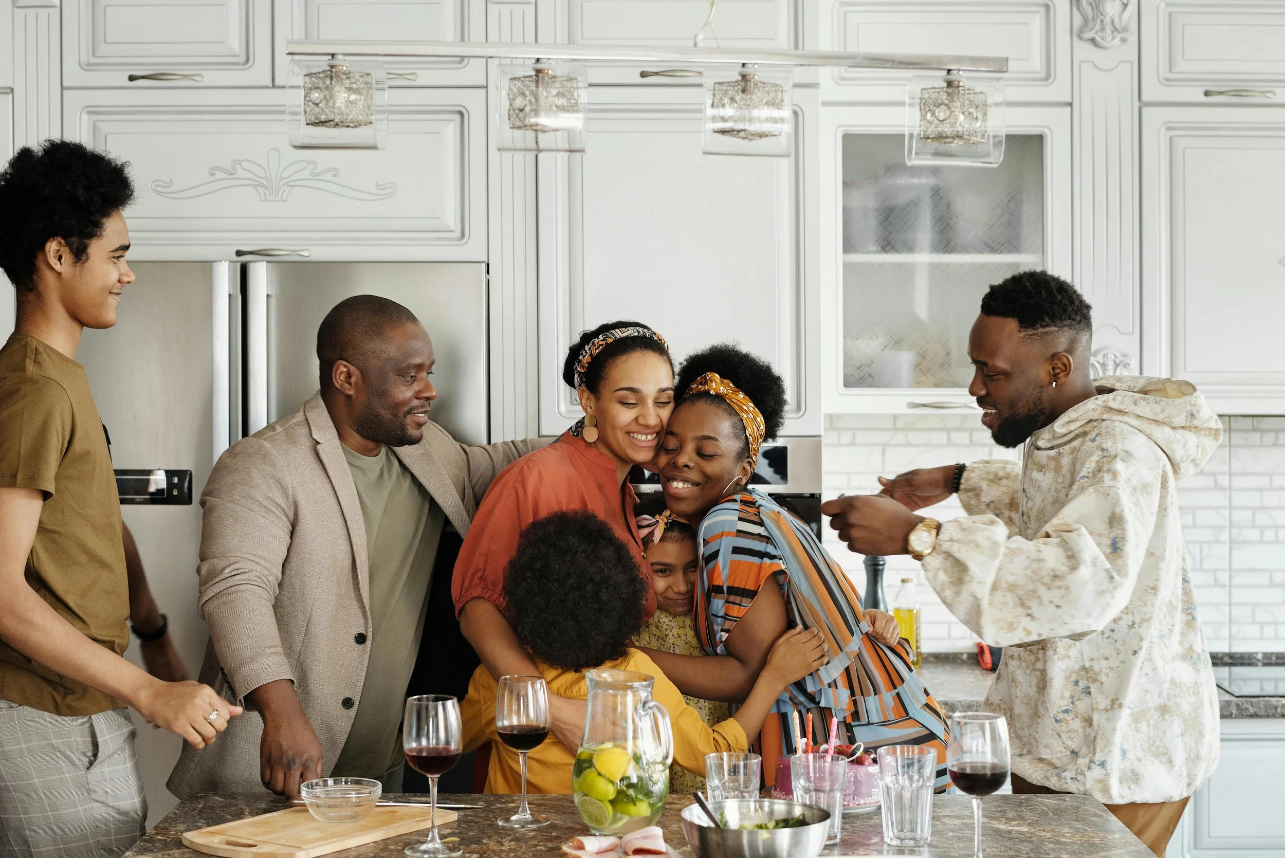 A multigenerational family celebrating in a kitchen, symbolizing the peace of mind and family harmony achieved through a completed Legacy Bundle.