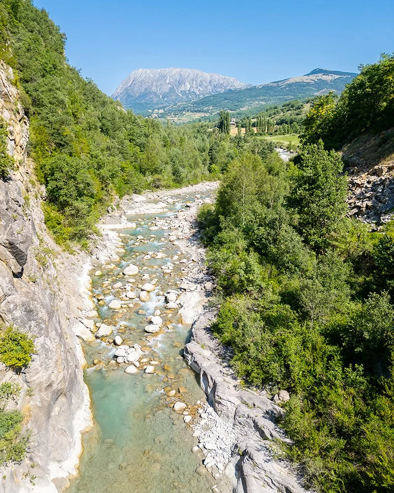 Personas haciendo rafting en un río con casco y chaleco salvavidas.
