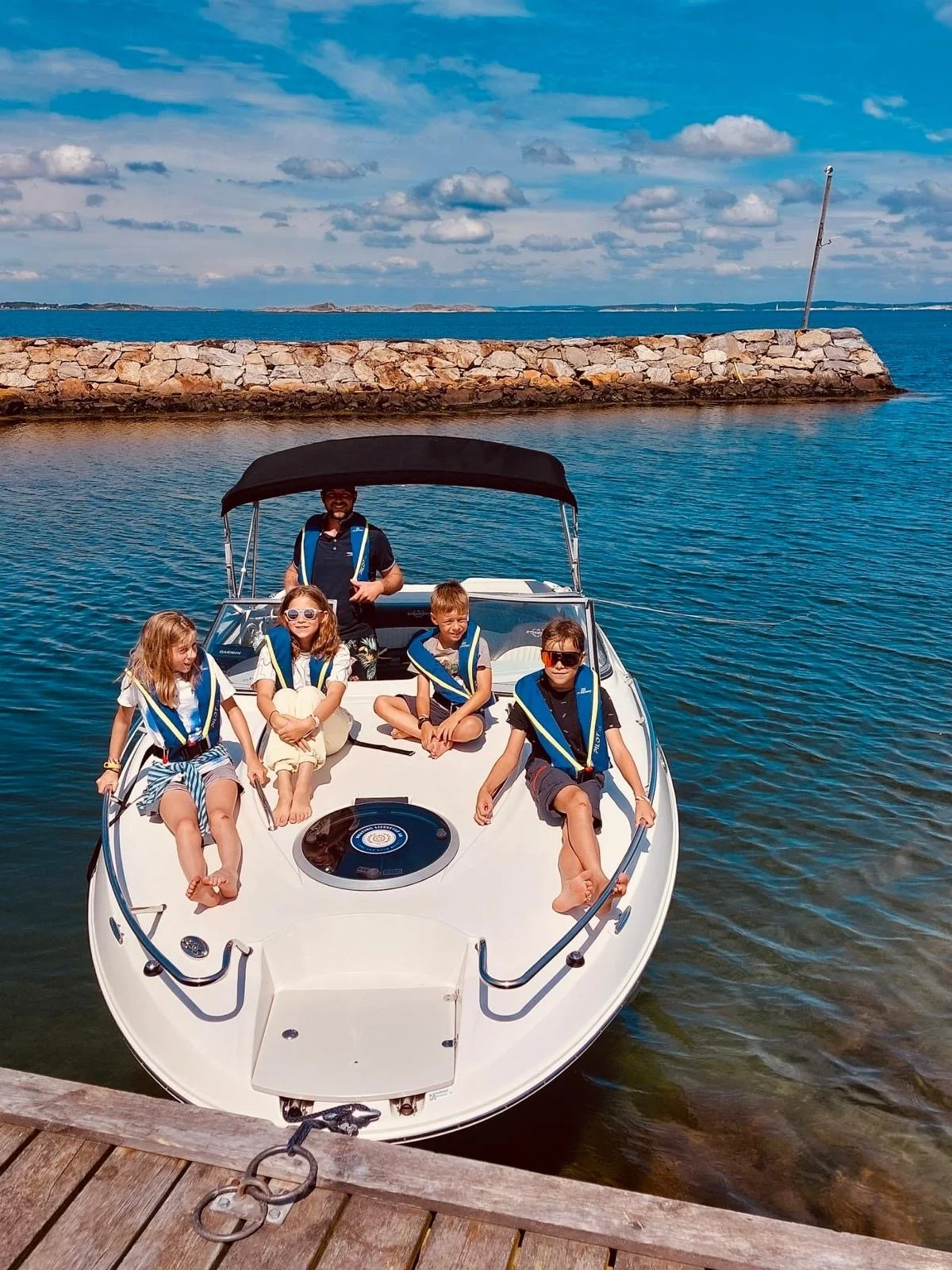 Family on private boat tour in Grebbestad archipelago Sweden near coastal pier