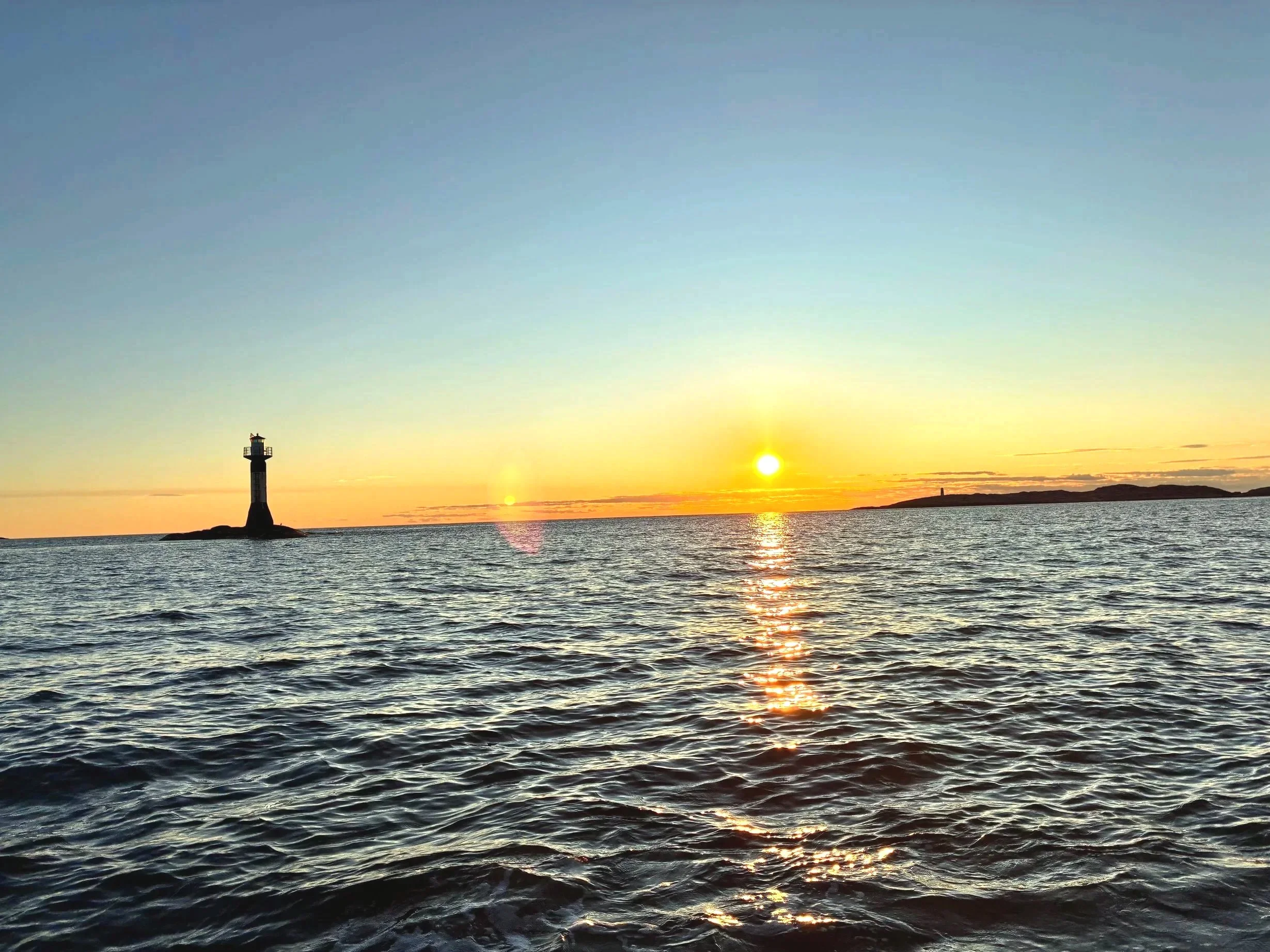 Sunset over the Swedish west coast archipelago near Grebbestad with lighthouse and open sea