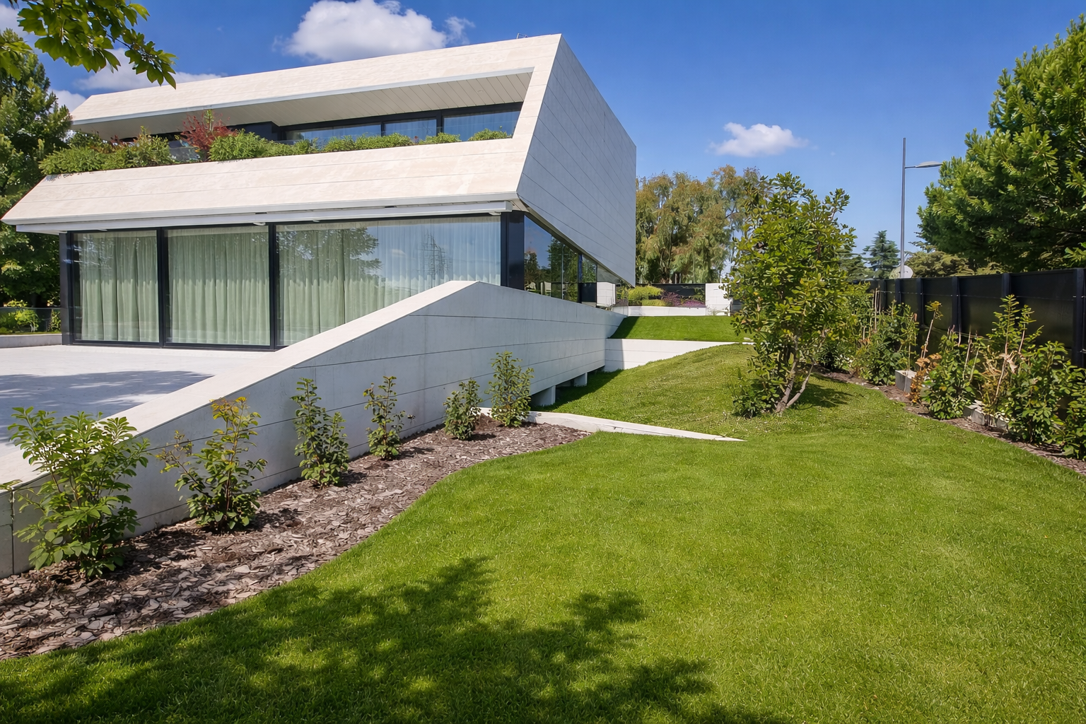 Casa moderna con jardín y árboles en un día soleado.