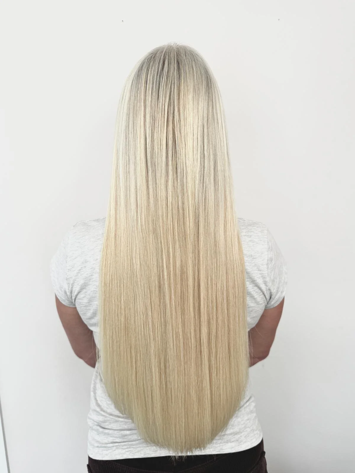 Back view of a woman with long, straight, platinum blonde hair