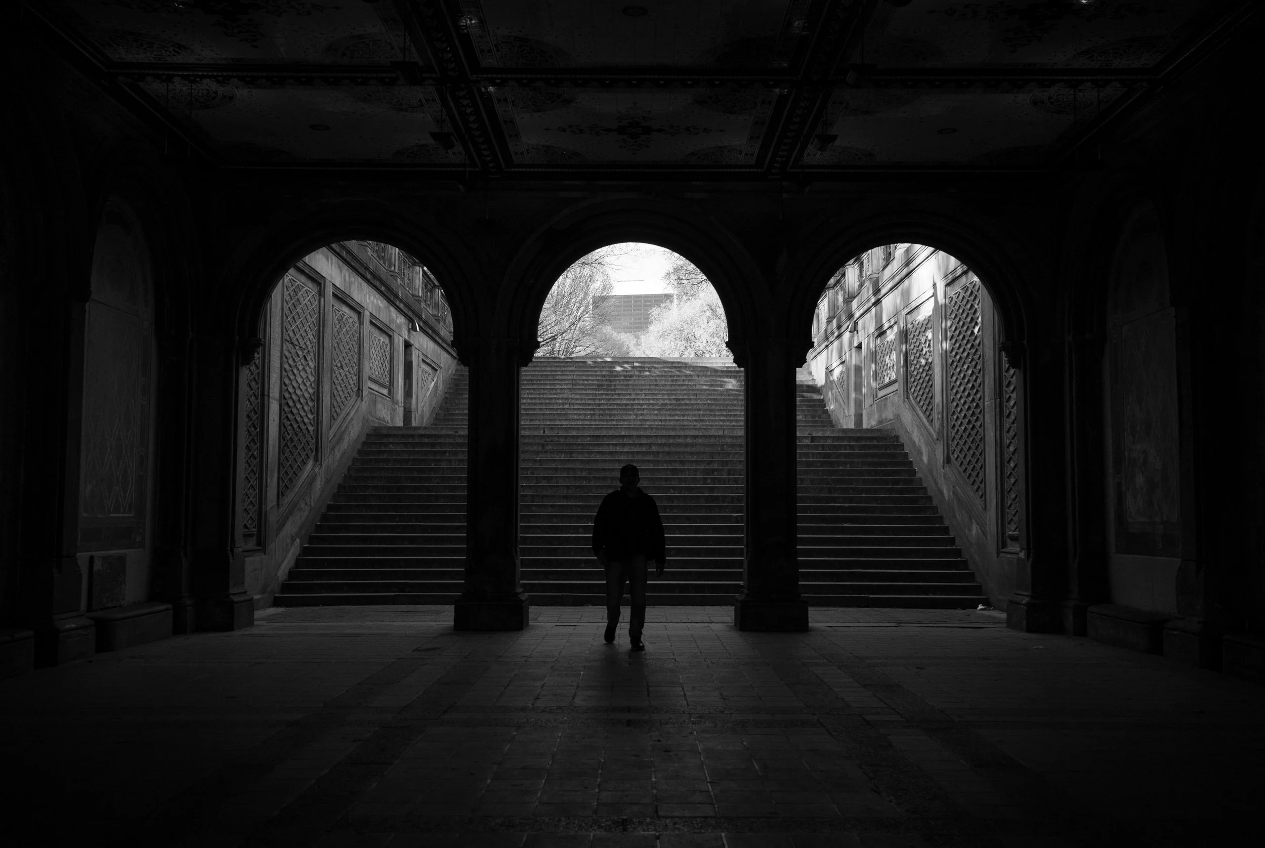 Anonymous figure walking through Bethesda Terrace, Central Park, black and white fine art photography by m.s.watkins
