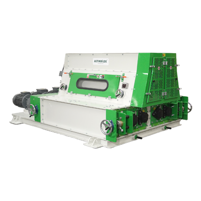 Industrial machine painted in white and green with control panels, knobs, and vents, used for manufacturing or processing