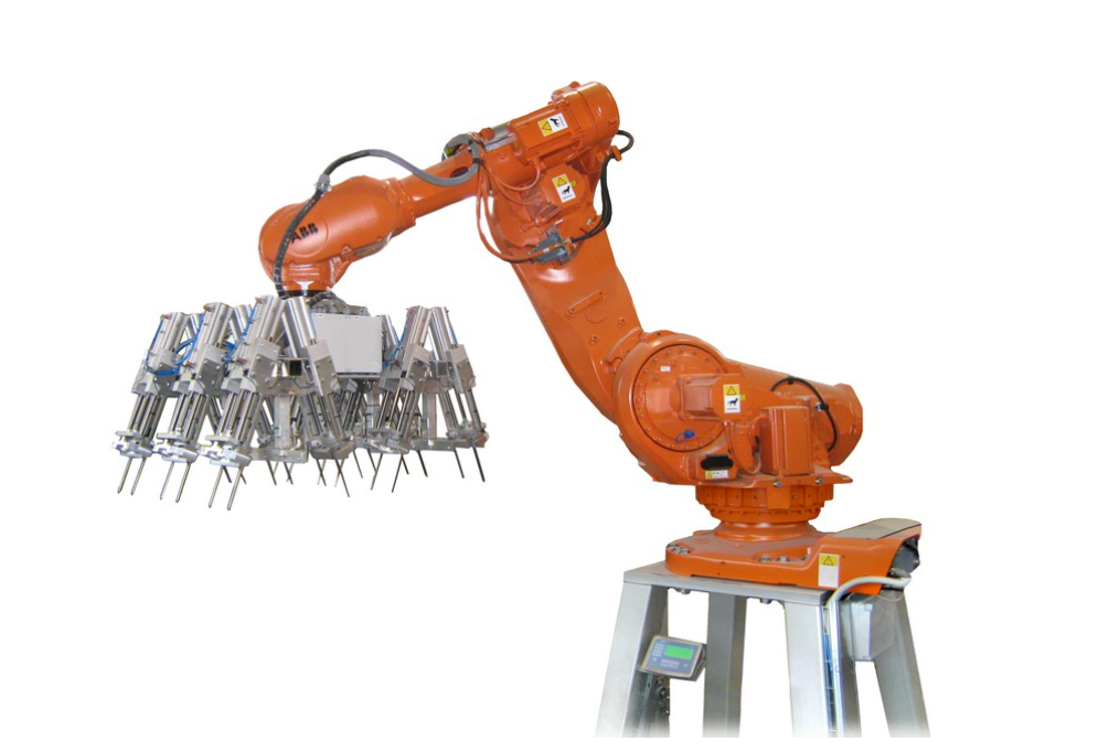 Orange industrial robotic arm interacting with a cluster of metal components on a white background.