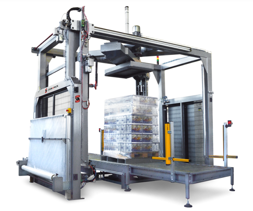 Automated pallet wrapping machine wrapping a pallet of boxes, positioned on a platform for shrink wrapping.