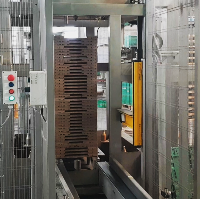 Industrial conveyor system moving cardboard boxes in a factory setting.