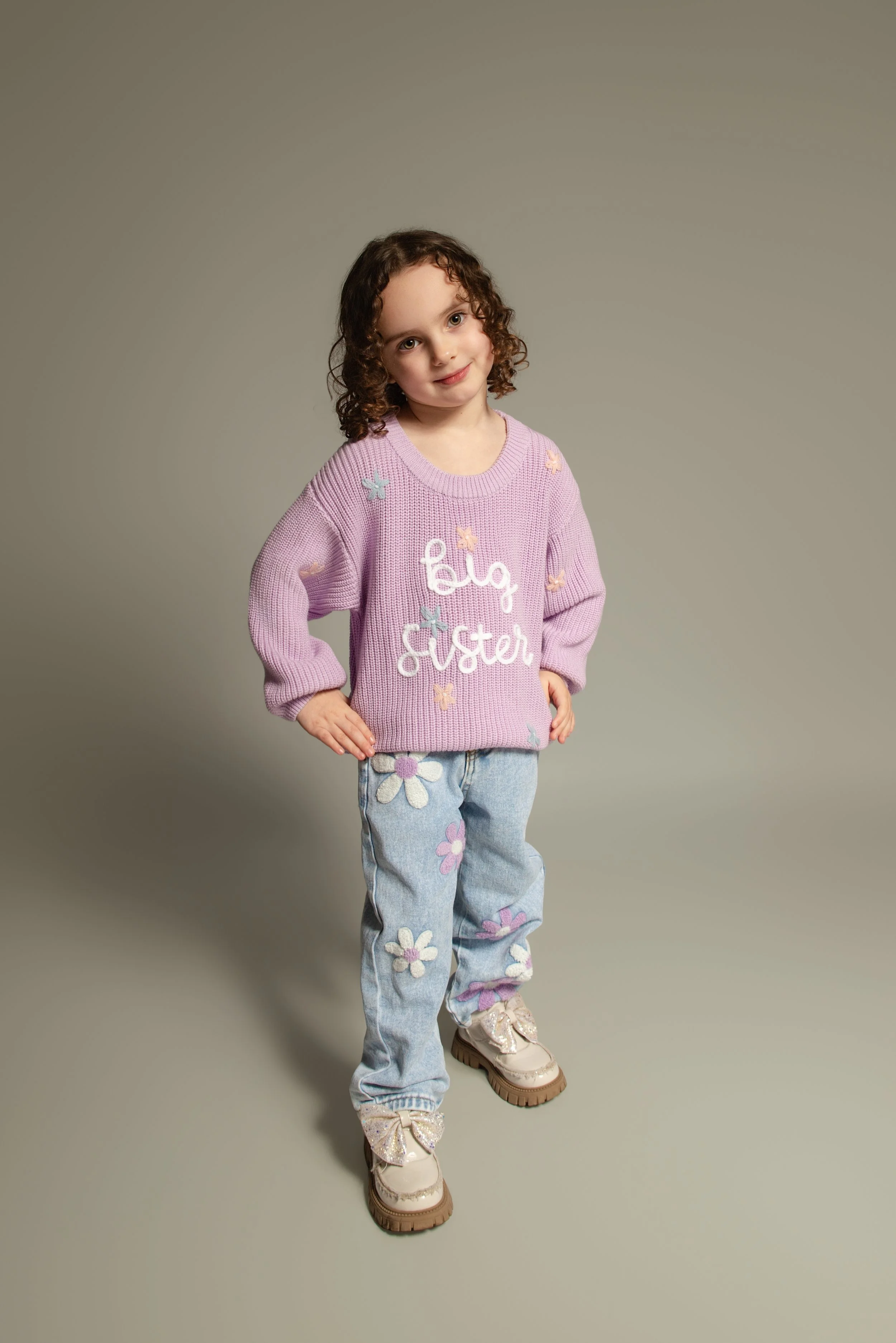 Child standing and posing in front of the camera for her portrait photo shoot in Bury, Manchester