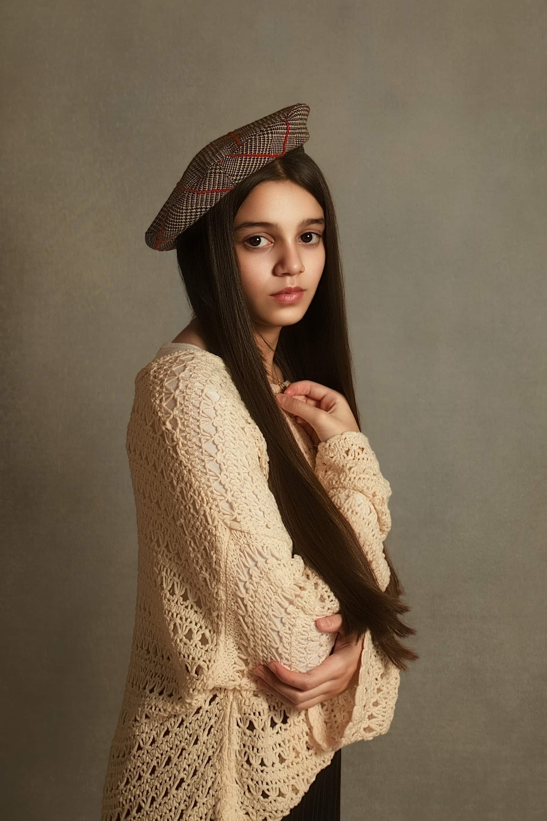 Fine art portrait of 12 year old girl with long dark hair wearing a beret, photographed at home in Bury, Manchester