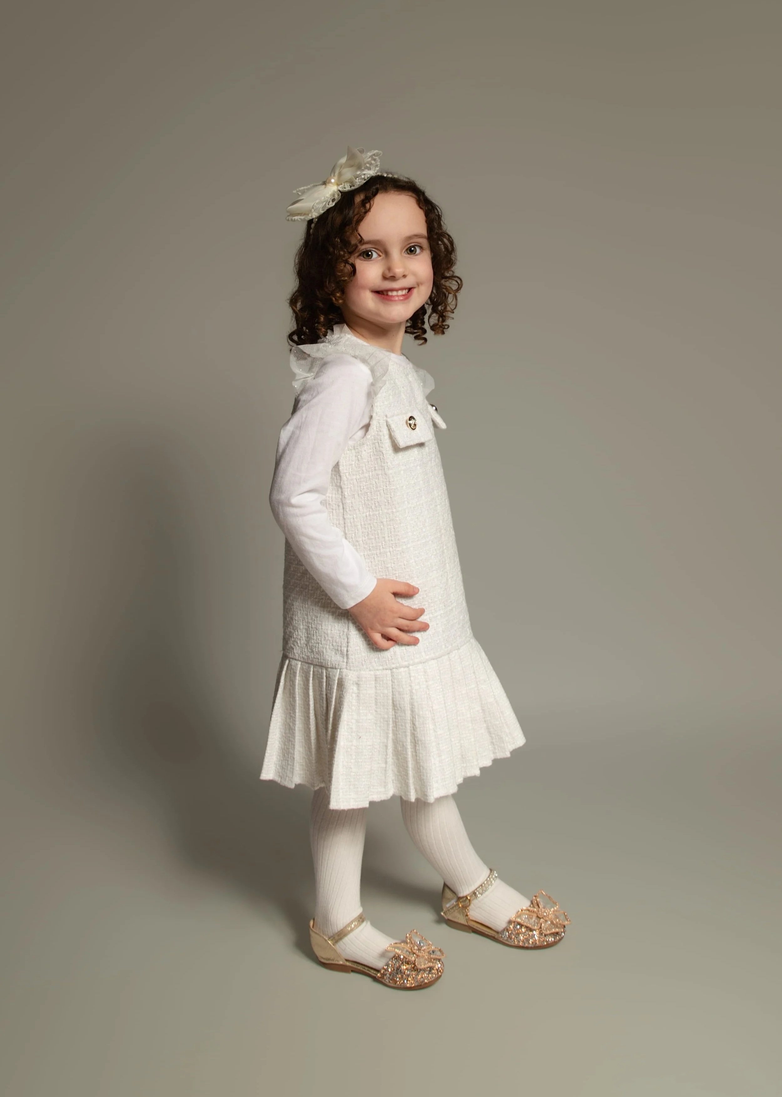 Studio style portrait of four year old girl on neutral background photographed at home in Bury, Manchester