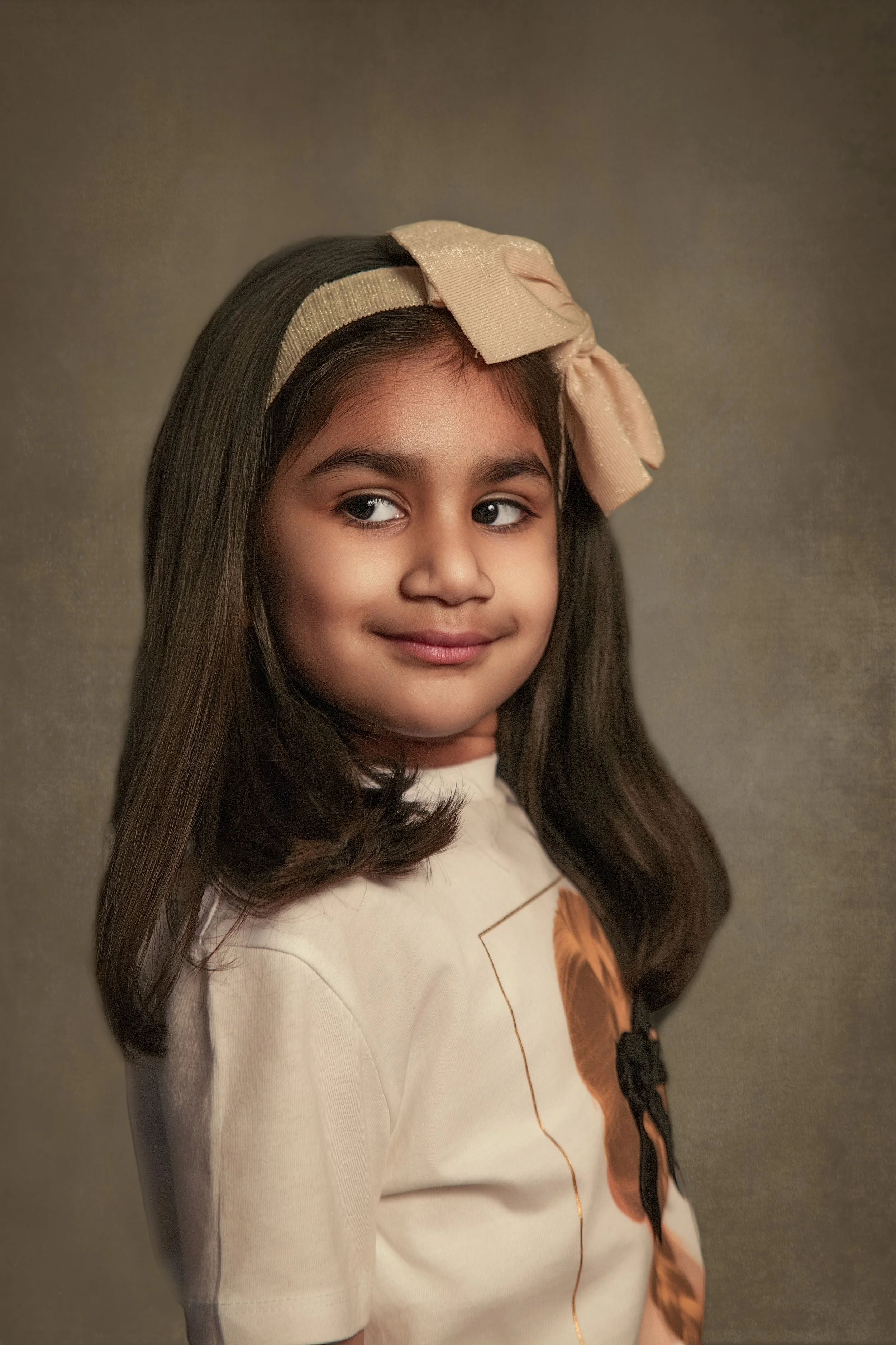 fine art children's portrait of a young girl in a white t-shirt and wearing a bow in her hair by children's portrait photographer Manchester