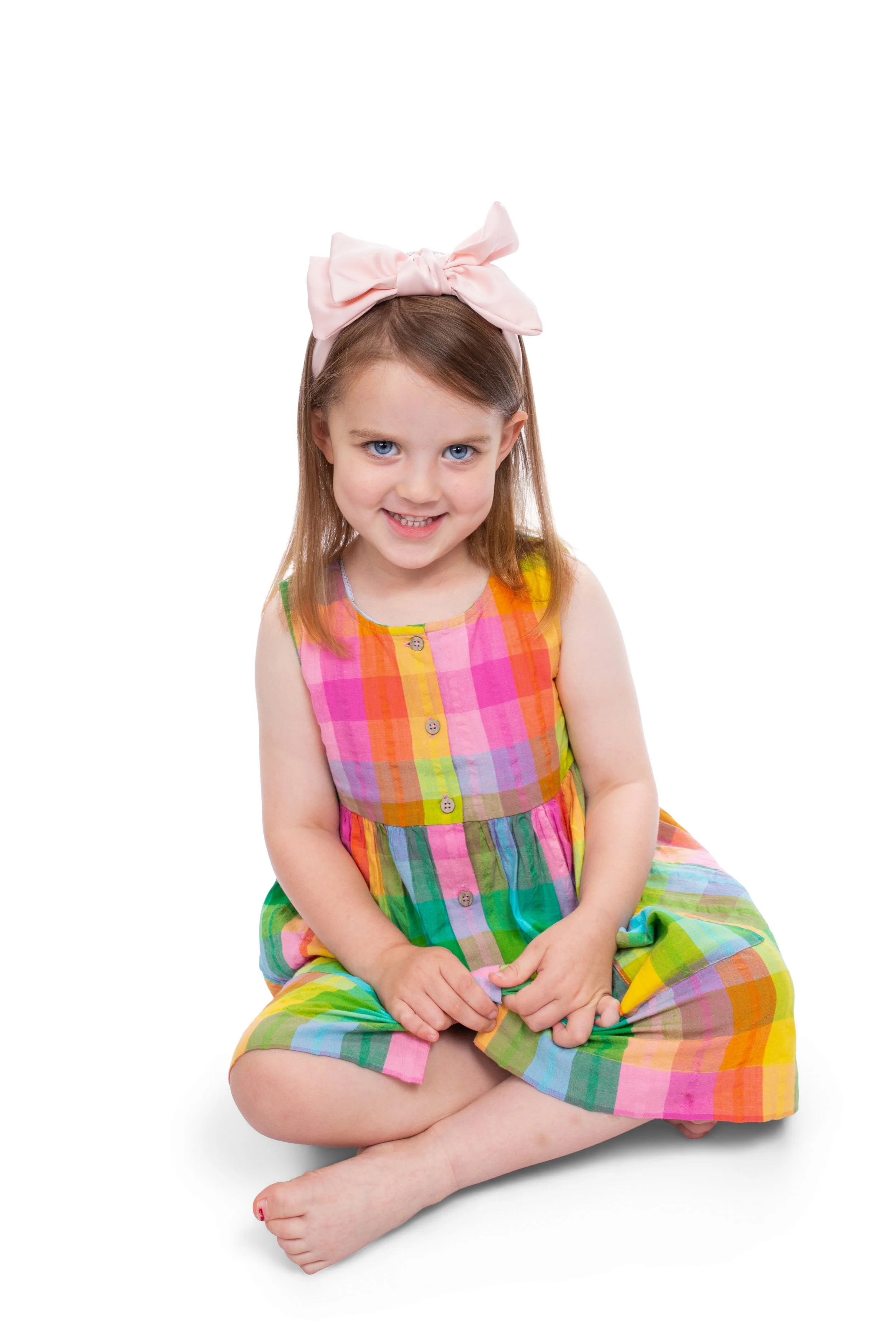 Young girl in colourful dress having a nursery portrait photograph in manchester