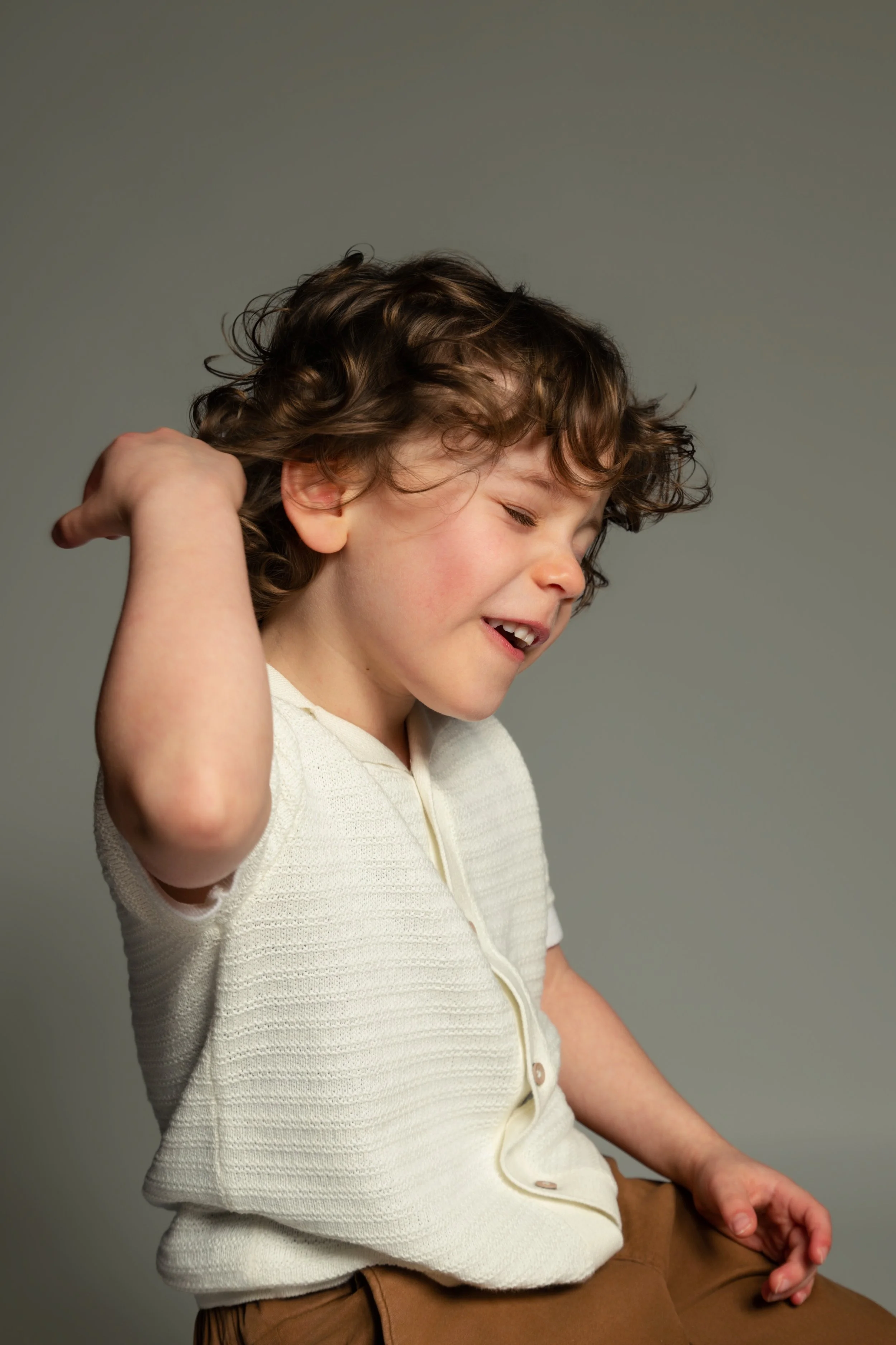 Studio-style children's portrait of young boy on neutral background photographed at home in Manchester