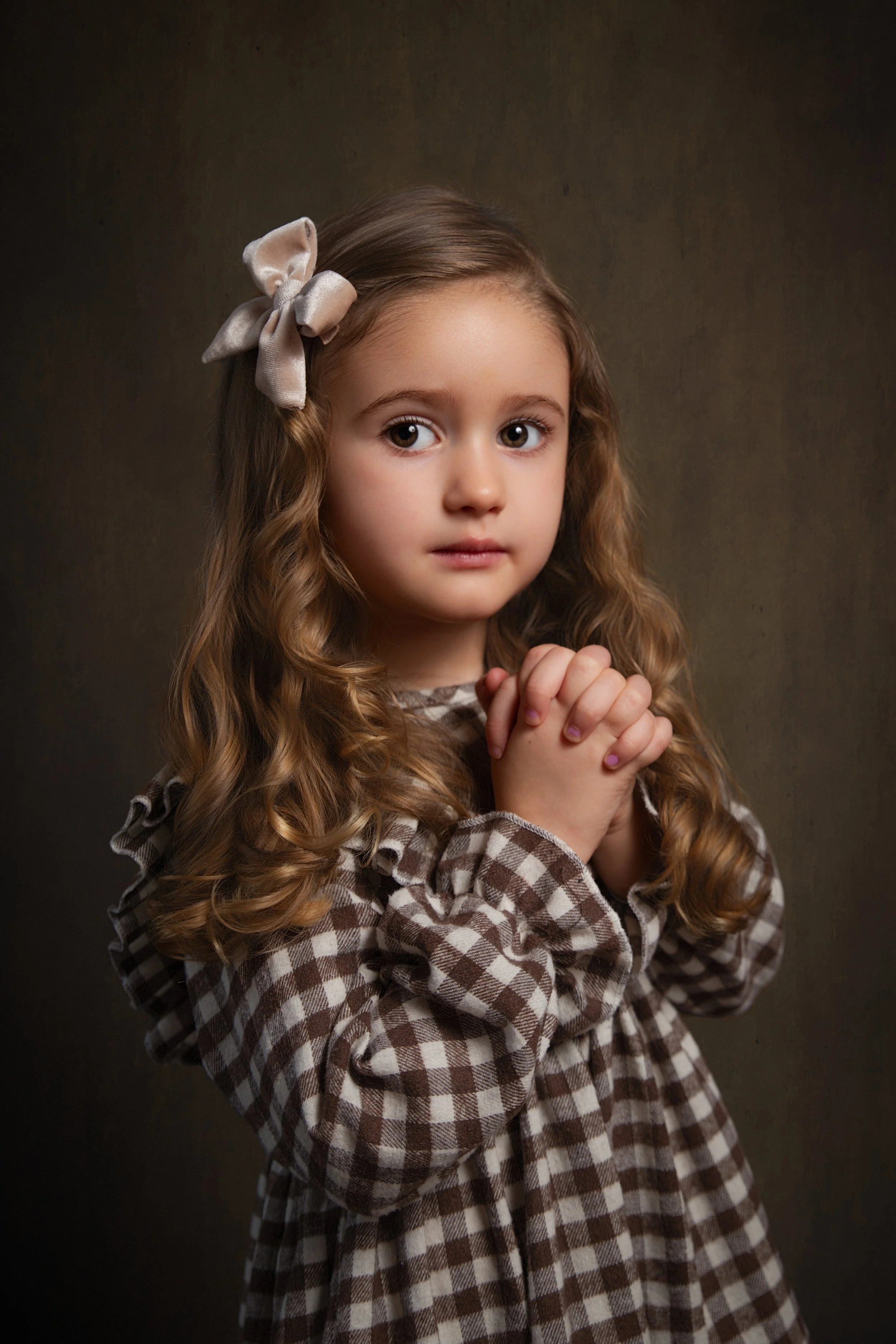 classic portrait of a girl with a bow in her hair with soft subtle lighting and bright eyes in greater manchester